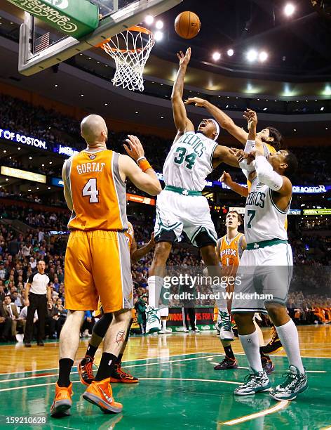 Paul Pierce of the Boston Celtics tips in a shot in front of Marcin Gortat of the Phoenix Suns during the game on January 9, 2013 at TD Garden in...