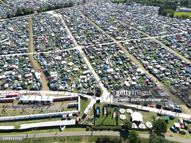 August 2023, Thuringia, Saalburg-Ebersdorf: Numerous tents and mobile homes are standing on the meadows and fields around the festival area before...
