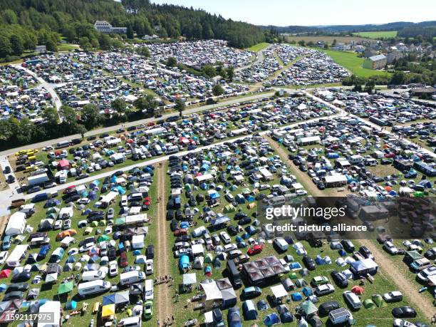 August 2023, Thuringia, Saalburg-Ebersdorf: Numerous tents and mobile homes are standing on the meadows and fields around the festival area before...