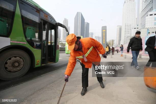 Year-old Chinese real estate mogul Yu Youzhen works as a street cleaner on January 2, 2013 in Wuhan, Hubei Province of China. Yu Youzhen gladly wakes...