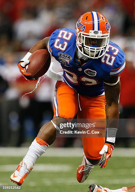 Mike Gillislee of the Florida Gators runs the ball against the Louisville Cardinals during the Allstate Sugar Bowl at Mercedes-Benz Superdome on...