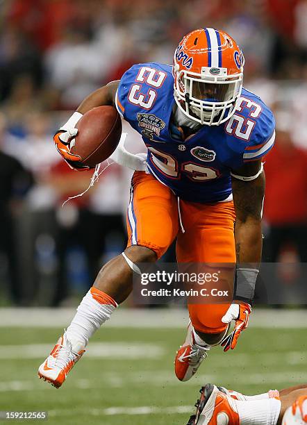 Mike Gillislee of the Florida Gators runs the ball against the Louisville Cardinals during the Allstate Sugar Bowl at Mercedes-Benz Superdome on...