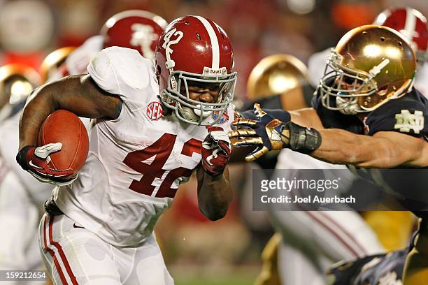 Eddie Lacy of the Alabama Crimson Tide runs with the ball against the Notre Dame Fighting Irish during the 2013 Discover BCS National Championship...