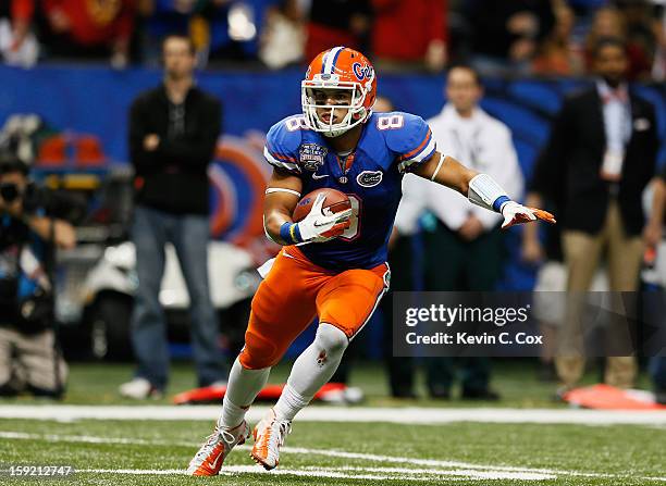 Trey Burton of the Florida Gators carries the ball against the Louisville Cardinals during the Allstate Sugar Bowl at Mercedes-Benz Superdome on...