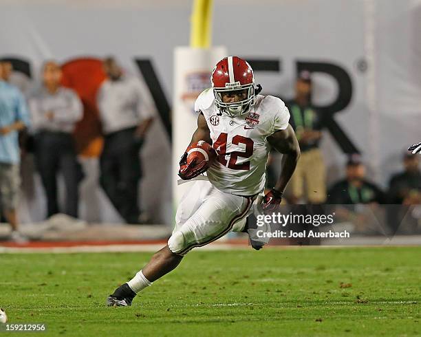 Eddie Lacy of the Alabama Crimson Tide runs with the ball against the Notre Dame Fighting Irish during the 2013 Discover BCS National Championship...