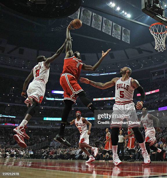 Larry Sanders of the Milwaukee Bucks leaps for a rebound between Loul Deng and Carlos Boozer of the Chicago Bulls at the United Center on January 9,...