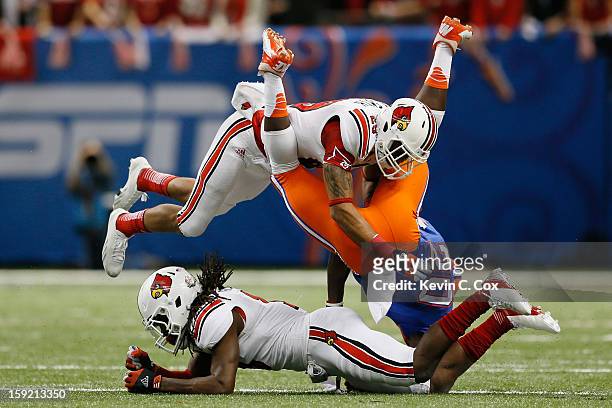 Terell Floyd and Hakeem Smith of the Louisville Cardinals break up a pass intended for Omarius Hines of the Florida Gators during the Allstate Sugar...