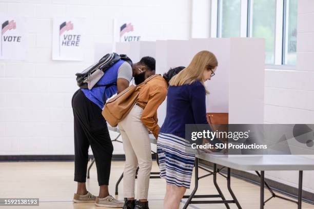 diverse people stand at voting booths to cast votes - bi partisan stock pictures, royalty-free photos & images