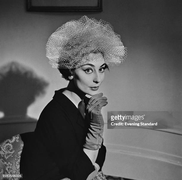 Woman models an 'Aurora' hat, Rotten Row, London, February 26th 1958.