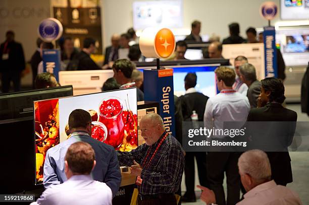 Attendees look over televisions at the Panasonic Corp. Booth at the 2013 Consumer Electronics Show in Las Vegas, Nevada, U.S., on Wednesday, Jan. 9,...