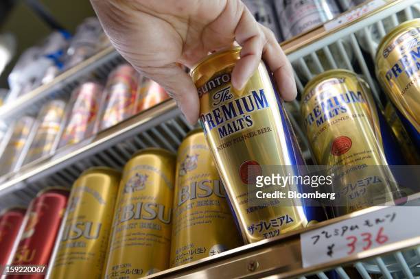 Cans of Suntory Holdings Ltd. Premium Malt's beer are displayed for sale in a liquor store in Kawasaki, Kanagawa Prefecture, Japan, on Wednesday,...