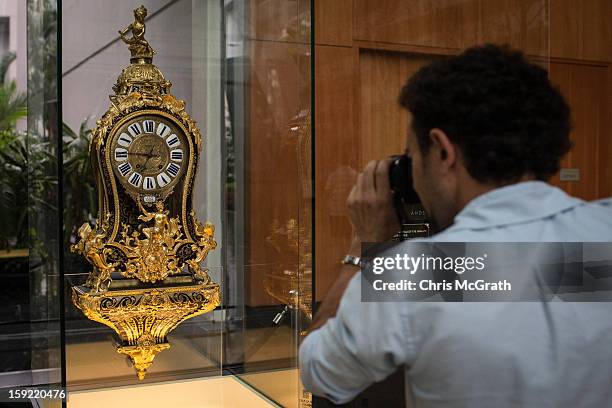 Man photographs a 1730 Boulle Marquetry Cartel clock on display January 9, 2013 at Marina Bay Sands in Singapore. To commemorate the Year of The...