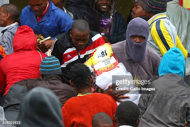 Striking farm workers run out of a Usave store as police arrive on January 9 in Cape Town, South Africa. The farm workers of De Doorns protested for...