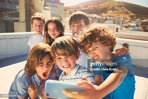 children taking self-portrait with smart phone - child mobile phone stock-fotos und bilder