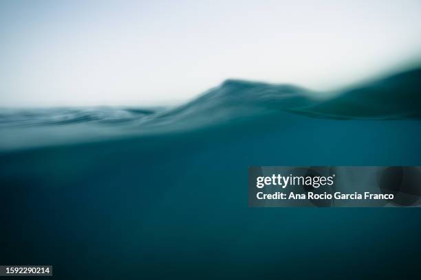 split view of blue ocean waters surface - wateroppervlak stockfoto's en -beelden