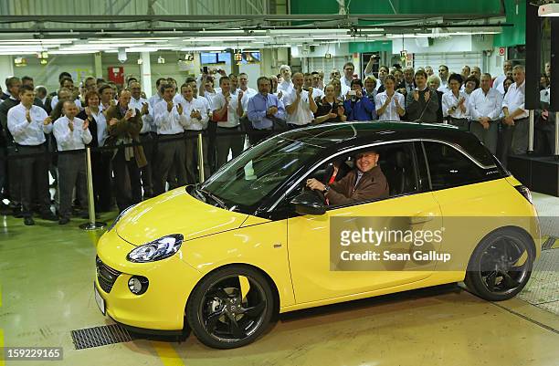 Steve Girsky, General Motors Vice Chairman and head of GM Europe, drives an Opel Adam car from the assembly line as factory workers look on during a...