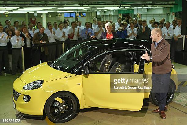 Steve Girsky, General Motors Vice Chairman and head of GM Europe, and German athlete Ariane Friedrich emerge from an Opel Adam car after driving it...