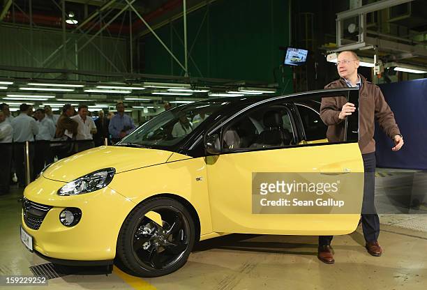 Steve Girsky, General Motors Vice Chairman and head of GM Europe, stands next to an Opel Adam car fresh from the assembly line as factory workers...