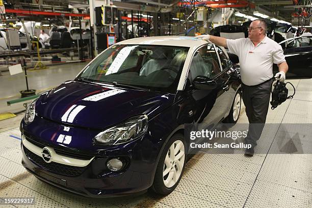 Worker checks a finished Opel Adam car at the assembly line shortly after a celebration to mark the launch of the new Opel compact car at the Opel...