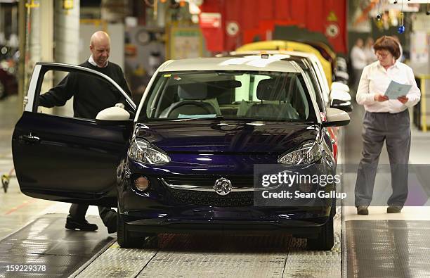 Worker check a finished Opel Adam car with Vauxhall branding at the assembly line shortly after a celebration to mark the launch of the new Opel...