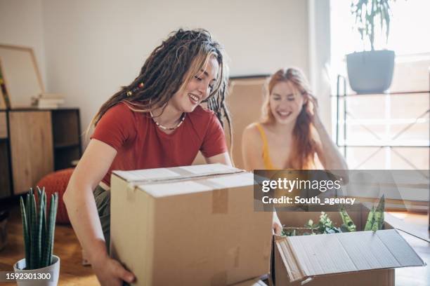 lesbian couple in their new apartment - new girlfriend stock pictures, royalty-free photos & images