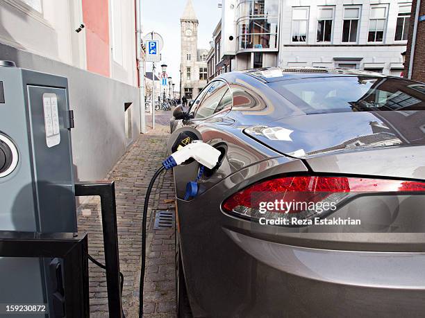 electric car at recharging station - electric vehicle charging station stock pictures, royalty-free photos & images