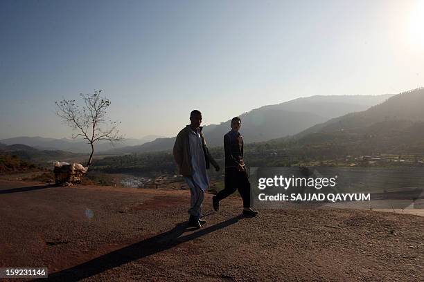 Pakistani Kashmiris walk on a road leading towards the town of Titrinot, some 30 kilometers north of Battal sector close of Pakistan-India border, on...