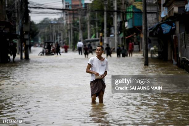 Resident wades along a flooded street following monsoon rains in Bago township, Bago region, on August 11, 2023. Floods and landslides caused by...