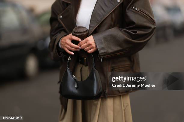 Anna Winter is seen wearing brown thick framed Bottega Veneta sunnies, white Frankie Shop cropped shirt, brown oversized and distressed Ducie London...