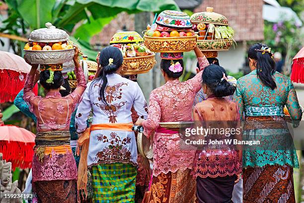 women carry temple offerings, bali - balinesische kultur stock-fotos und bilder