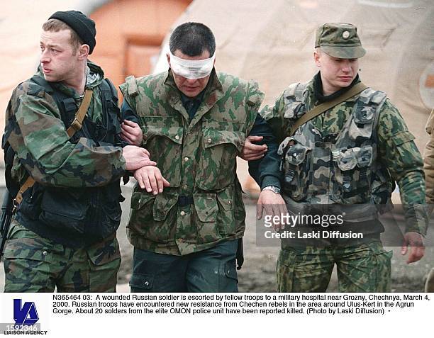 Wounded Russian soldier is escorted by fellow troops to a military hospital near Grozny, Chechnya, March 4, 2000. Russian troops have encountered new...