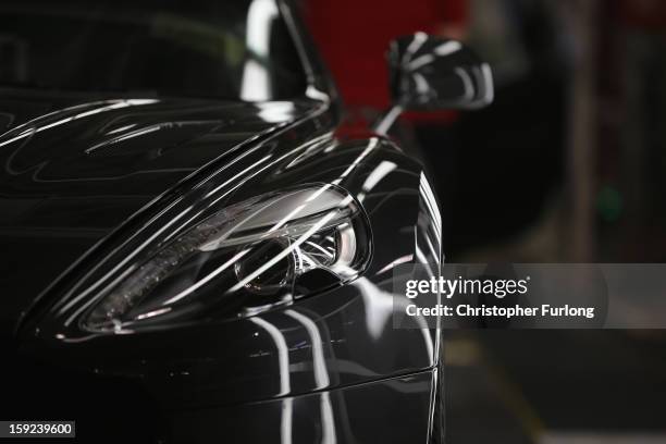 An Aston Martin is inspected by hand inside a light booth at the company headquarters and production plant on January 10, 2013 in Gaydon, England....