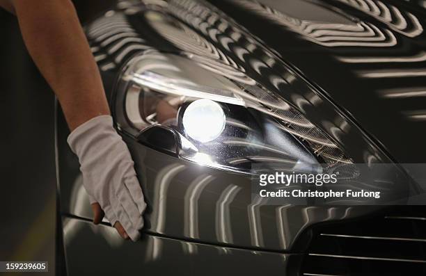 An Aston Martin Vanquish is inspected by hand inside a light booth at the company headquarters and production plant on January 10, 2013 in Gaydon,...