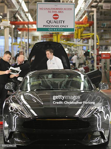 Technicians in quality control inspect an Aston Martin motor car at the company headquarters and production plant on January 10, 2013 in Gaydon,...