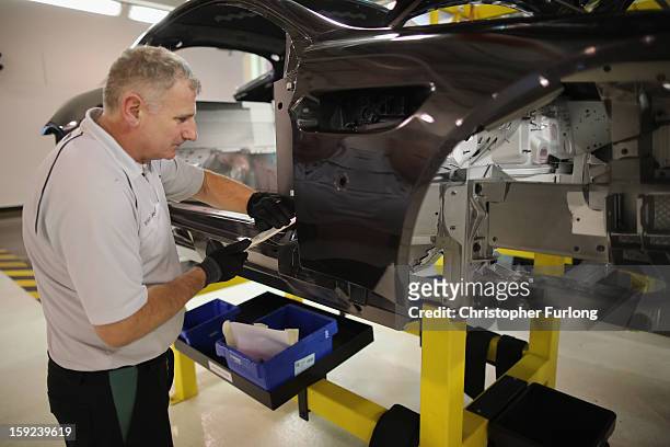 Technicians work on the assembly line building Aston Martin motor cars at the company headquarters and production plant on January 10, 2013 in...