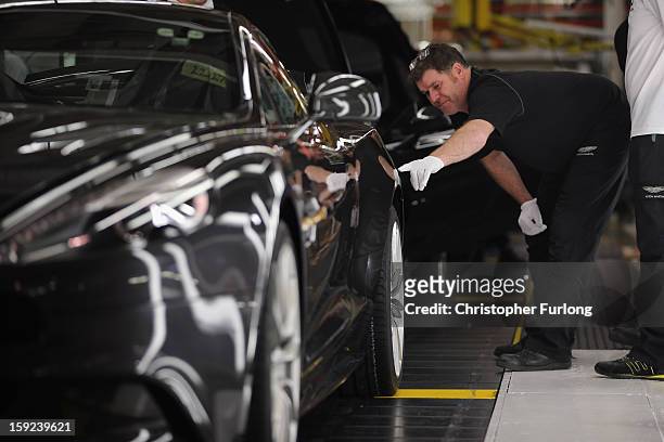 Technicians in quality control inspect an Aston Martin motor car at the company headquarters and production plant on January 10, 2013 in Gaydon,...
