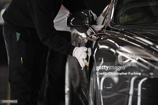 Technicians in quality control inspect an Aston Martin motor car at the company headquarters and production plant on January 10, 2013 in Gaydon,...