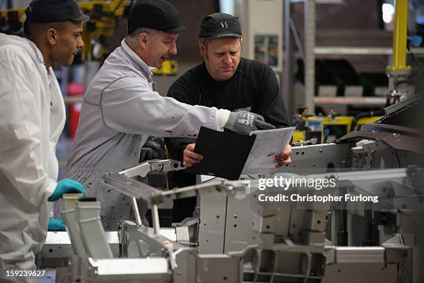 Technicians work on the assembly line building Aston Martin motor cars at the company headquarters and production plant on January 10, 2013 in...