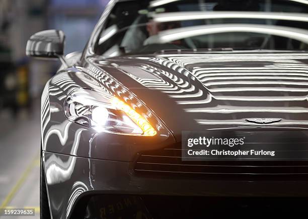 An Aston Martin Vanquish is inspected by hand inside a light booth at the company headquarters and production plant on January 10, 2013 in Gaydon,...