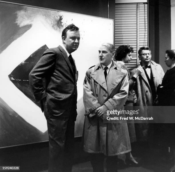 At an exhibition of his work in the at Sidney Janis Gallery, American abstract expressionist Robert Motherwell poses with Dutch American artist...