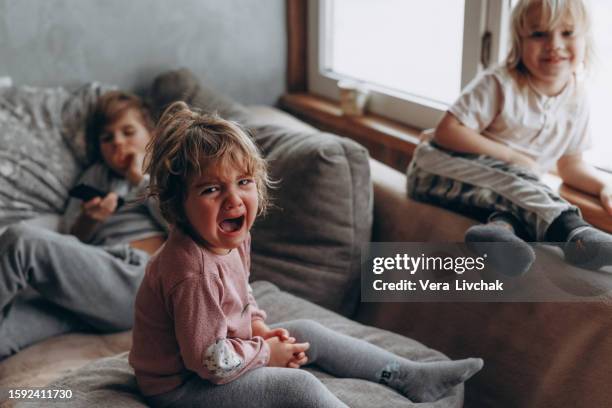 sad girl crying on sofa. - weinen stock-fotos und bilder