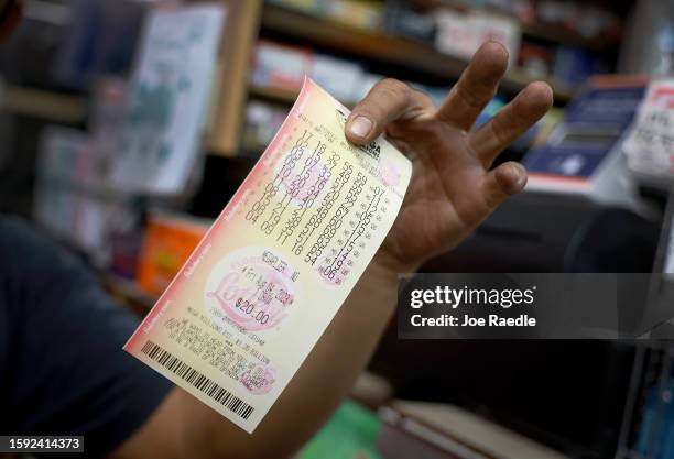 Hopeful lottery ticket holder shows off his Mega Millions lottery ticket that he bought at Bob's News & Books store on August 04, 2023 in Fort...