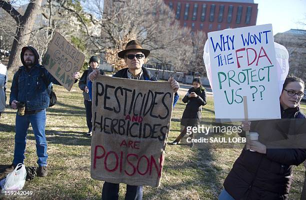 Demonstrators hold signs supporting family farms and opposing genetically engineered food as part of the group Safe Food Activists and Concerned...