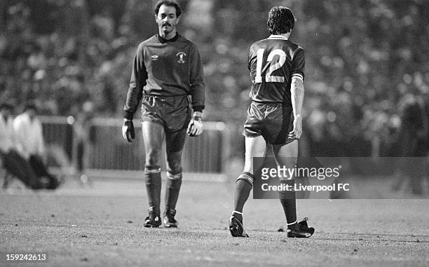 Liverpool goalkeeper Bruce Grobbelaar walks past Liverpool's Steve Nicol, looking pensive as he prepares to face the first Roma spot kick, from...