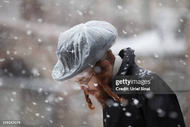 An Ultra-orthodox Jewish man walks in the snow in the Mea Shearim religious neighborhood on January 10, 2013 in Jerusalem, Israel.