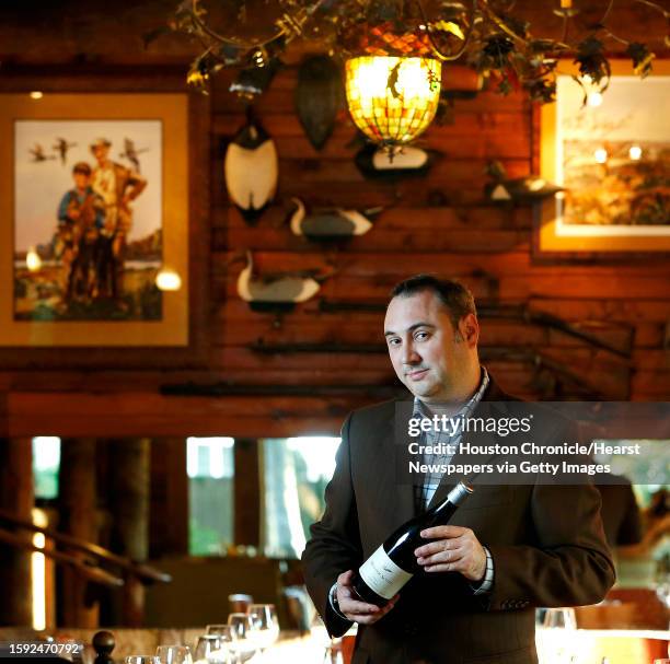 Marc Borel, the beverage director at Rainbow Lodge, holds a 2013 pinot noir from Walter Scott, a winery in the Willamette Valley in Oregon, inside...