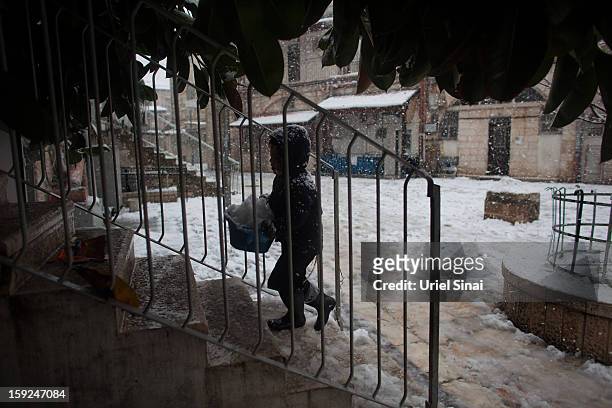 An Ultra-orthodox Jewish boy plays in the snow in the Mea Shearim religious neighborhood on January 10, 2013 in Jerusalem, Israel.