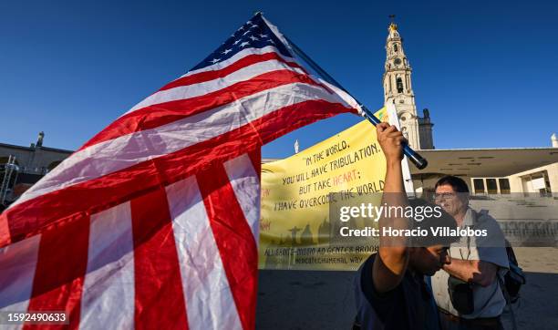 Pilgrims display the national flag and a banne upon arrival in late afternoon at the sanctuary premises as members of the faithful of all ages and...