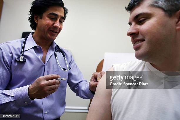 Aaron Lemma receives a flu shot by Dr. Sassan Naderi at the Premier Care walk-in health clinic which administers flu shots on January 10, 2013 in New...