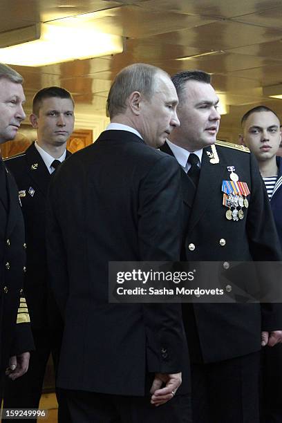 Russian President Vladimir Putin poses for a photo with officers during his visit to the heavy nuclear-powered missile cruiser Pyotr Veliky at the...